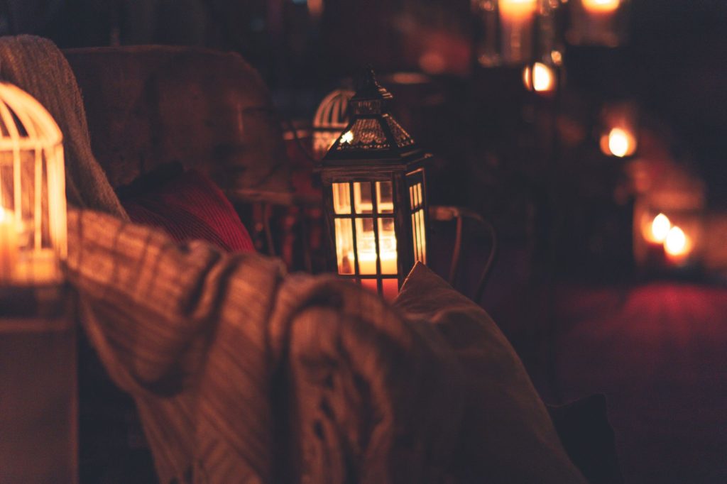 Ambiance cosy du soir avec plusieurs bougies allumées créant une atmosphère chaleureuse dans un salon