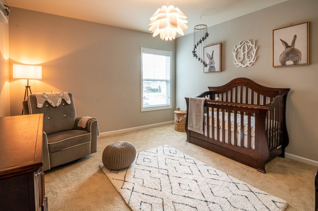 Coin chambre de bébé avec lit à barreaux et décoration douce et neutre