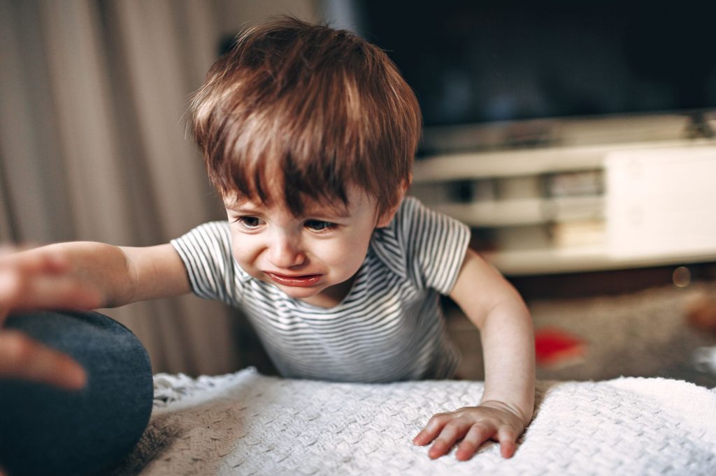 Jeune enfant en pleine crise de colère, visage crisé par les pleurs
