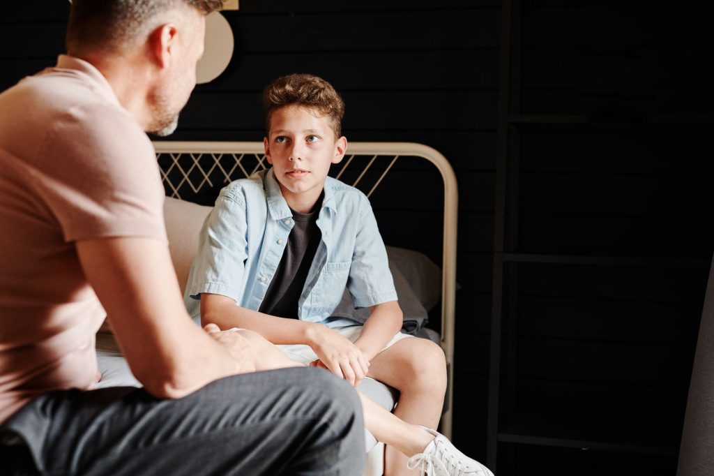 Parent à la hauteur de son enfant, en train de lui parler doucement